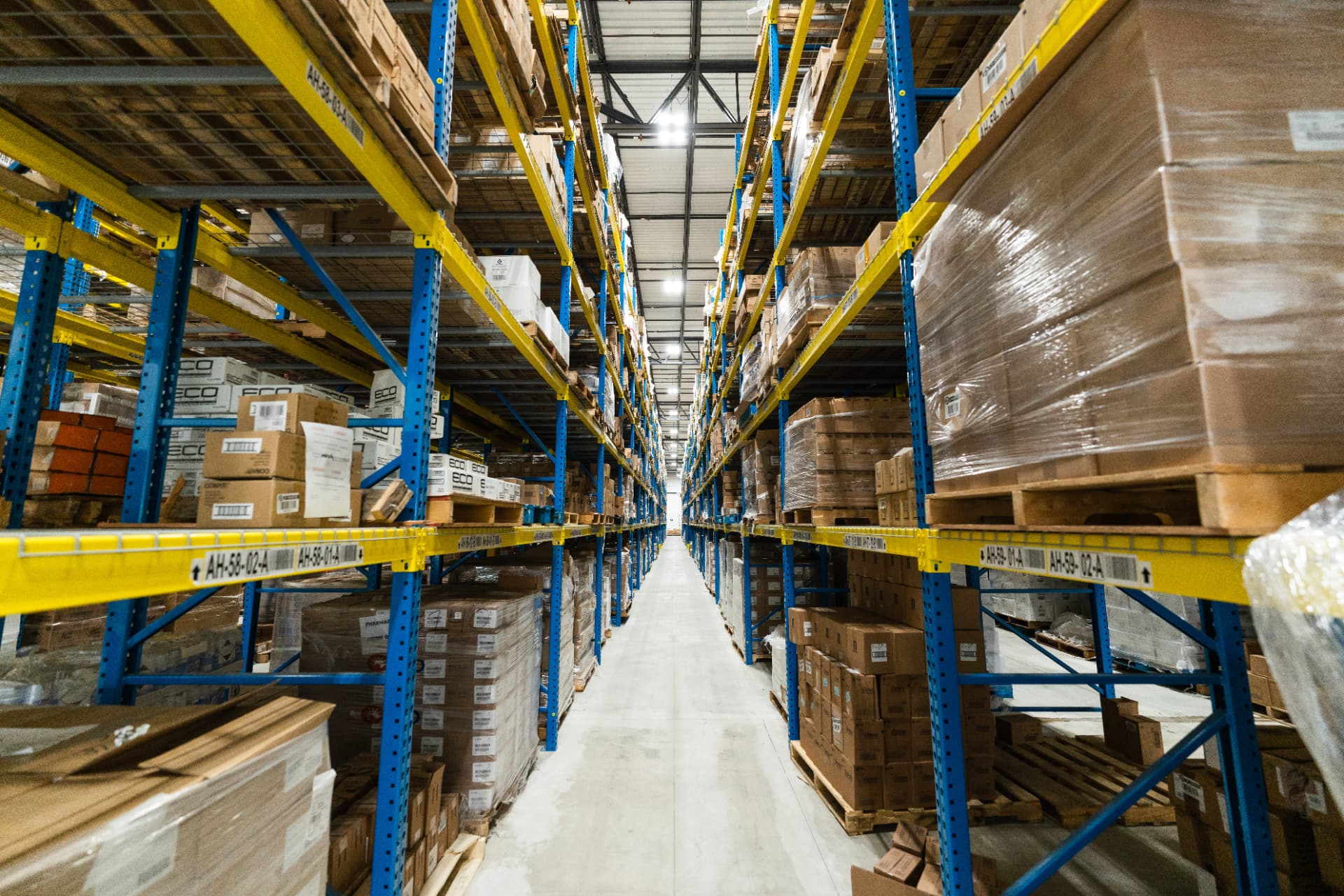 Warehouse aisle with tall shelves of boxed inventory